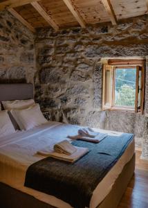 sypialnia z łóżkiem w kamiennej ścianie w obiekcie Casas da Peneda - Geres w mieście Gavieira