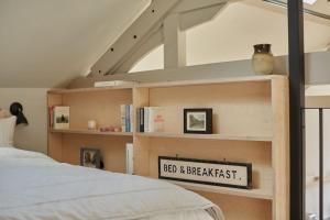 a bedroom with a bed and a book shelf at Converted Chapel with Scandi design interior in New Buckenham