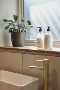 two bottles ofodorizers sitting on a counter in a bathroom at Converted Chapel with Scandi design interior in New Buckenham
