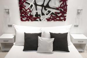 a bedroom with a white bed with black and white pillows at Vatican Grand Suite in Rome