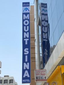 una señal de hotel en el lateral de un edificio en MOUNT SINA HOTEL By AURA en Dubái