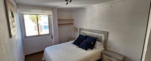 una camera da letto con un letto con cuscini blu e una finestra di Inside of the sea a Tavernes de Valldigna
