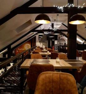 een restaurant met houten tafels, stoelen en verlichting bij L auberge de l Entre Potes-Boho Chic in Maffle