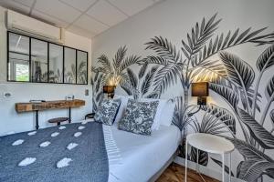 a bedroom with a bed with a mural of palm trees at Le Provence in Gémenos