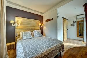 a bedroom with a large bed and a wooden headboard at Contact Hôtel Le Provence in Gémenos