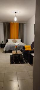 een woonkamer met een bed en een bank bij Pretty stay in Nairobi
