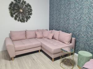 a living room with a pink couch and a table at Ghencea Residence 158 Floor 10 in Bucharest