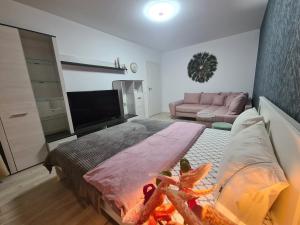 a bedroom with a large bed and a couch at Ghencea Residence 158 Floor 10 in Bucharest