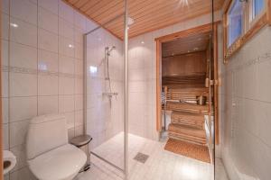e bagno con servizi igienici e doccia in vetro. di Levillas Kätkänkuja 3 Villas a Levi