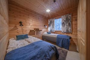 sypialnia z 2 łóżkami w drewnianym domku w obiekcie Levillas Kätkänkuja 3 Villas w mieście Levi