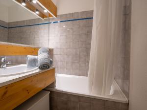 里蒙紐耶的住宿－Apartment Balcons D'Olympie-1 by Interhome，带浴缸、水槽和淋浴的浴室
