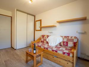 a bedroom with a bed and a table with a bottle of wine at Apartment Balcons d'Olympie 305 - A by Interhome in Les Menuires +16 photos