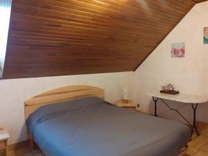 a bed in a room with a wooden ceiling at le belvedere de mallet in Sarrus
