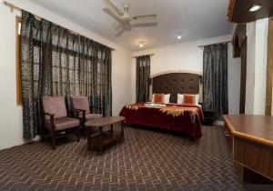 シュリーナガルにあるHotel Al Azrahのベッドとデスクが備わるホテルルームです。