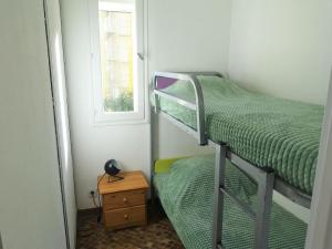 een kleine kamer met 2 stapelbedden en een raam bij Apartment Maisons sur la Plage-1 by Interhome in Gruissan