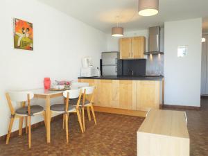 a kitchen with a table and chairs in a room at Apartment Maisons sur la Plage by Interhome in Gruissan