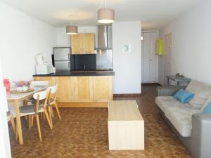 een woonkamer en een keuken met een bank en een tafel bij Apartment Maisons sur la Plage-1 by Interhome in Gruissan