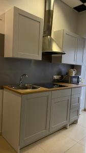 a kitchen with white cabinets and a sink at Sports Hostel in Kaunas
