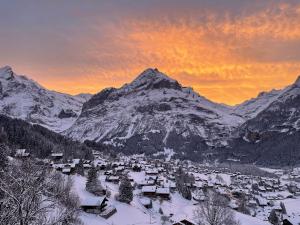 a village covered in snow with a mountain in the background at Apartment Chalet Shangri La by Interhome in Grindelwald