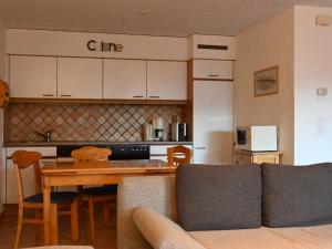 ein Wohnzimmer mit einem Sofa und einem Tisch sowie eine Küche in der Unterkunft Apartment Caroubier 2 by Interhome in Ovronnaz