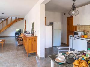 eine Küche und ein Wohnzimmer mit einem Kühlschrank und einem Tisch in der Unterkunft Holiday Home ferme by Interhome in Agizoux