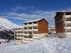 a apartment building in the snow with a mountain at Apartment Les Asters-1 by Interhome in Les Menuires