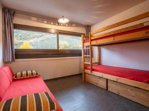 a bedroom with two bunk beds and a window at Apartment Brelin-6 by Interhome in Les Menuires