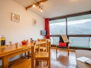 une salle à manger avec une table et une grande fenêtre dans l'établissement Apartment Brelin-6 by Interhome, aux Menuires