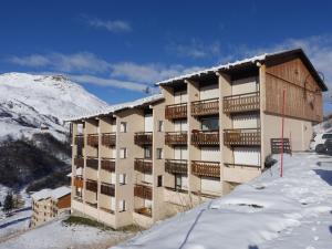 un edificio en la nieve frente a una montaña en Apartment Les Asters-30 by Interhome, en Les Menuires