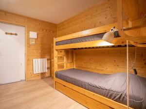 レ・メニュアールにあるApartment Les Mélèzes-5 by Interhomeの木造キャビン内の二段ベッド付きのベッドルーム1室を利用します。
