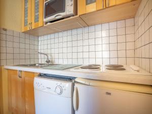 a kitchen with a stove and a washing machine at Apartment Les Mélèzes-5 by Interhome in Les Menuires
