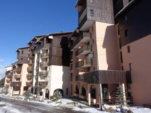 an apartment building with balconies in the snow at Apartment L'Argousier-8 by Interhome in Les Menuires