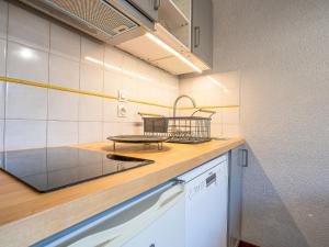 a kitchen with a counter with a table on it at Apartment Balcon d'Olympie 745 - B by Interhome in Les Menuires
