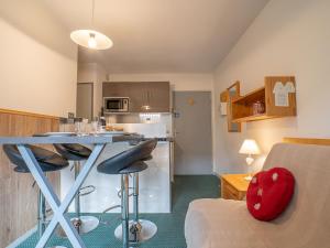 eine Küche und ein Wohnzimmer mit einem Tisch im Zimmer in der Unterkunft Apartment Le Jettay-15 by Interhome in Les Menuires