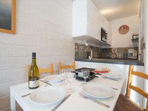 una cucina con tavolo, piatti e una bottiglia di vino di Apartment Armoise-1 by Interhome a Les Menuires