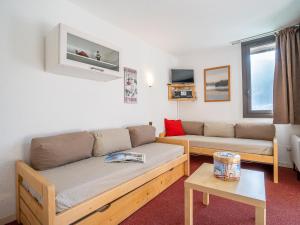 un soggiorno con divano e tavolo di Apartment Armoise-1 by Interhome a Les Menuires