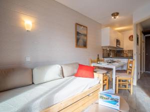 un soggiorno con divano e una cucina di Apartment Armoise-1 by Interhome a Les Menuires