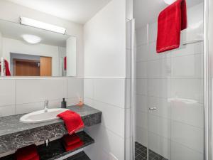 a bathroom with a sink and a mirror and red towels at Apartment Vorreiter - UTD152 by Interhome in Uttendorf