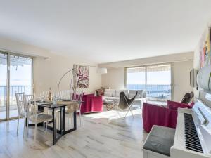 a living room with a table and a piano at Apartment Les Miradors by Interhome in Menton