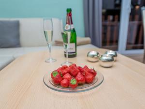 a plate of strawberries on a table with a bottle of champagne at Apartment An der Eine-1 by Interhome in Stangerode