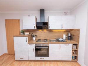 La cuisine est équipée de placards blancs et d'un four avec plaques de cuisson. dans l'établissement Apartment An der Eine-3 by Interhome, à Stangerode