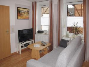 a living room with a couch and a television at Apartment An der Eine-3 by Interhome in Stangerode