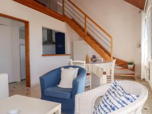 PlozévetにあるHoliday Home Balades au bord de l'eau - PZV100 by Interhomeのリビングルーム(青い椅子、テーブル付)