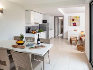 Il dispose d'une cuisine et d'un salon avec une table et des chaises blanches. dans l'établissement Apartment MB6 Loggia - MNI107 by Interhome, à Moriani-Plage