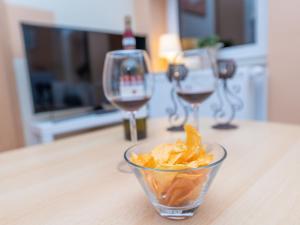un tazón de patatas fritas y dos copas de vino en Apartment An der Eine-2 by Interhome en Stangerode
