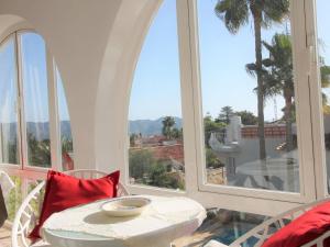 una mesa blanca y sillas en un balcón con ventanas en Holiday Home Colombia 16 by Interhome, en Alfaz del Pi