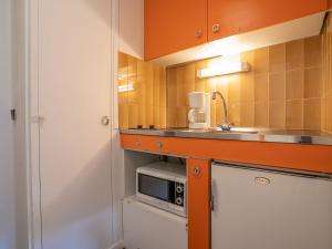 a small kitchen with a sink and a microwave at Apartment Armoise 73 by Interhome in Les Menuires