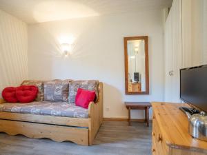 a living room with a couch with red pillows on it at Apartment Armoise 73 by Interhome in Les Menuires +18 photos