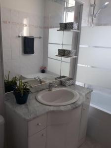 a white bathroom with a sink and a mirror at Le gîte des cascades in Bassy