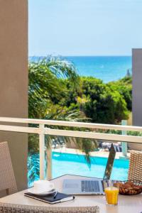 een laptop op een tafel met uitzicht op de oceaan bij Apartment MB4 piscine by Interhome in Moriani Plage